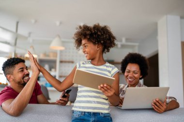 Teknolojik cihazlara takıntılı mutlu Afro-Amerikan ailesi dijital tablet, bilgisayar, akıllı telefonlar kullanıyor. İnternet sitesi, iş, eğitim ve internet üzerinden okuma, film veya bir mim için teknoloji