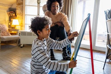 Mutlu Afrikalı Amerikalı çocuk, bekar annesi ya da öğretmeniyle matematik egzersizleri yapıyor. Eğitim insanları eğlenceli konsept