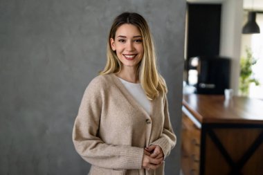 Gri arka planda poz veren mutlu bir kadının portresi. Mutlu insanlar konsepti.