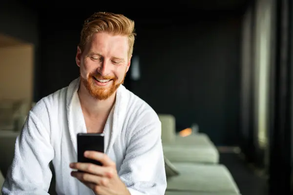 Junger Mann Nutzt Smartphone Für Die Arbeit Oder Zum Entspannen Stockbild