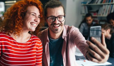 İki mutlu, neşeli iş adamının kendi portresi toplantı sırasında ofiste eğleniyor. Başlangıç meslektaşı mutluluk tasarımcısı konsepti.