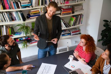 Ofisteki çeşitli çalışanlar yeni projeleri için yeni fikirleri tartışırken beyin fırtınası sırasında eğleniyorlar. Yönetim kurulundaki çok ırklı iş arkadaşları brifingde fikir alışverişinde bulundular..