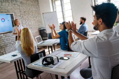 İşletme eğitmeniyle aynı sınıfta olan bir grup insan. Modern ofiste masa başında oturan ve bilgi ve rehberliği paylaşan deneyimli bir öğretmenin konuşmasını dinleyen bir grup erkek ve kadın çalışan.