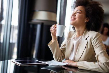 Kahve molası sırasında ofiste dijital tabletini kullanan zeki Afrikalı Amerikalı genç girişimci kadın portresi.