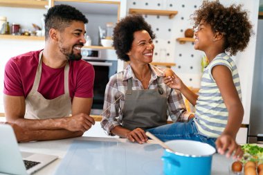 Mutlu Afro-Amerikan ailesi mutfakta eğleniyor ve birlikte yemek pişiriyor. Evde sağlıklı yiyecekler..