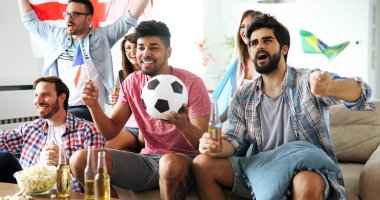 Televizyon izleyen ve takımını destekleyen mutlu bir arkadaş grubu.