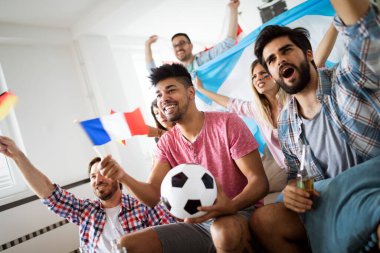 Çok ırklı bir grup insan futbol maçını kutluyor ve eğleniyor.