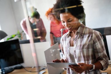 Modern başlangıç ofisinde takım olarak çalışan çok ırklı iş adamları ve yazılım geliştiricileri grubu