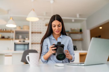 Woman working on laptop in home. Freelance photographer edit photos on computer. Professional photography business. Girl workspace with computer and photo camera. Creative artist lifestyle clipart