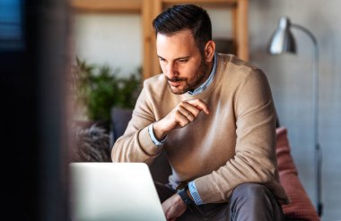 Ofiste dizüstü bilgisayarla çalışan gülümseyen bir iş adamı. Bilgisayarda uzaktan eğitim, sanal eğitim kullanan genç öğrenci ya da uzaktan öğretmen.