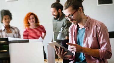 Yoğun bir modern işyerinde çalışan genç ve mutlu bir adamın portresi..
