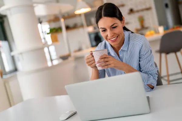 stock image Young beautiful woman using computer to check social media, working or read emails. Creative business person working from home with digital devices.