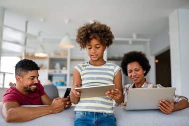 Teknolojik cihazlara takıntılı mutlu Afro-Amerikan ailesi dijital tablet, bilgisayar, akıllı telefonlar kullanıyor. İnternet sitesi, iş, eğitim ve internet üzerinden okuma, film veya bir mim için teknoloji