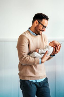 Yeni doğmuş bebeğini kucaklayan ve öpen bir babanın portresi. Erkek ebeveyn çocuğunu tutuyor. Otantik yaşam tarzı dokunaklı bir an. Bekar baba aile hayatı konsepti.