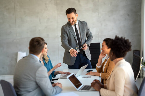 CEO businessman leader with diverse coworkers team, executive managers group at meeting. Multicultural professional businesspeople working together on research plan in boardroom.
