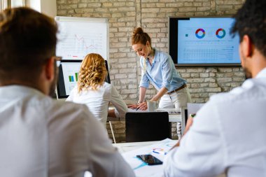 Başarılı bir iş kadını CEO 'su meslektaşlarına gelir verilerini gösteriyor, iş semineri atölyesinde modern ofiste büyük bir ekran yapmayı planlıyor..