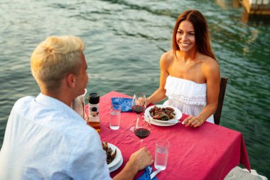 Balayı çifti yaz tatilinde tropik bir plajda özel, romantik bir akşam yemeği yiyorlar..