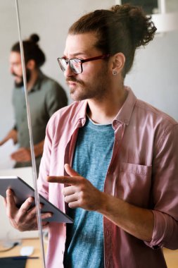 Başarı tabletli genç iş adamı, geleceğin uygulama teknolojisi için araştırma ve programlamada yenilik. Girişimci iş sitesi IT yazılımı için gelecekçi ağ, analiz ve geliştirici