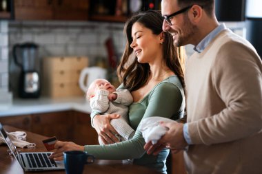 Evde internetten internetten alışveriş yapan çocuklu neşeli bir aile. Modern yaşam tarzı mutlu aile bebeği e-ticaret kavramını seviyor