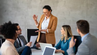 İşletme bürosundaki meslektaşlarıyla birlikte çalışırken analitik rapor sunan başarılı çoklu etnik çeşitlilikte iş adamları