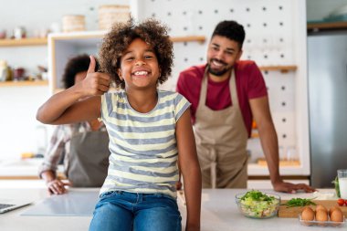 Mutlu Afro-Amerikan ebeveynler ve çocuklar mutfakta sağlıklı yiyecekler hazırlarken eğleniyorlar. Aile mutluluğu eğlence konsepti