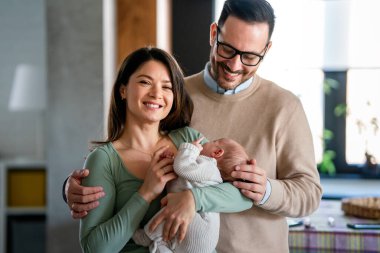Aile sevgisi bebek konsepti. Genç ebeveynler yeni doğan çocukla mutlu anlar geçirirler.
