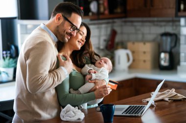 Evde internetten internetten alışveriş yapan çocuklu neşeli bir aile. Modern yaşam tarzı mutlu aile bebeği e-ticaret kavramını seviyor