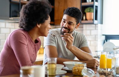 Modern mutfakta taze yemek hazırlarken mutlu genç siyah çift eğleniyor.