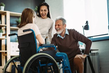 Tekerlekli sandalyede özürlü çocuklu, çok ırklı mutlu bir aile. Tek ebeveynlik