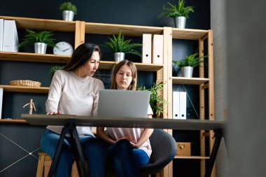 Evde eğitim gören genç kızına yardım eden mutlu bekar bir anne. İnsanlar, aile teknolojisi kavramı.