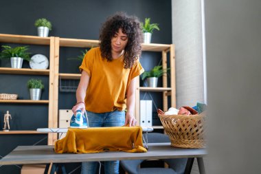 Mutlu Afro-Amerikan kadın portresi evde ütü yapıyor..