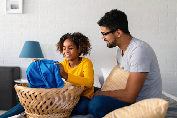 Happy black daughter helping father do household and domestic chores together. Happy family concept.
