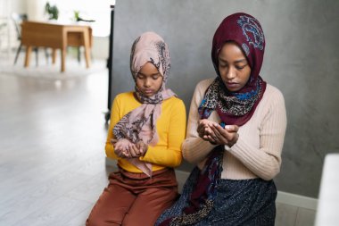 Güzel Müslüman anne ve çocuk İslami dua ediyorlar. Dini ritüel kavramı