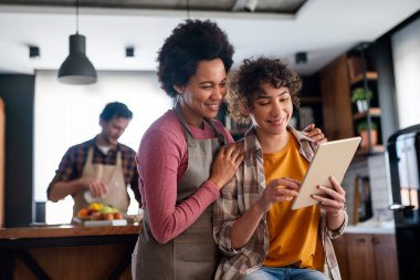 Çok ırklı mutlu bir aile mutfakta birlikte eğleniyor. Ebeveyn çocuk birlikte konsepti