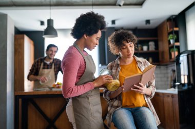 Eğitim, aile ve öğrenme kavramı. Tablet bilgisayarlı anne ve kızı evde ödev yapıyor.