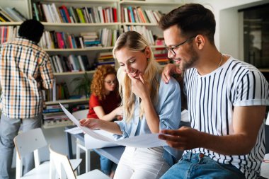 Gülümseyen çeşitli meslektaşlar toplantı odasında toplanmış mali istatistikleri tartışıyorlar. Mutlu çok ırklı iş arkadaşları ofis toplantılarında işbirliği yaparken eğleniyorlar. Takım çalışması konsepti.