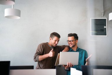 Dijital tablet kullanan mutlu iş arkadaşları, toplantı odasında dizüstü bilgisayar. İki genç iş adamı toplantı sırasında tartışıyorlar. Çeşitli girişimciler takım olarak çalışıyor..