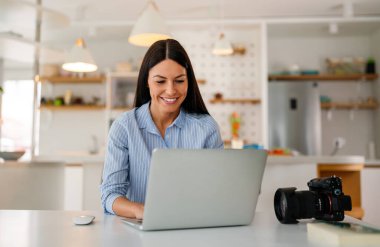 Ofiste çalışan fotoğraf makineli dizüstü bilgisayarı olan yaratıcı bir kadın. İş adamları online pazarlama yapıyor. Başarılı bağımsız yaratıcı sanatçı kız işi..