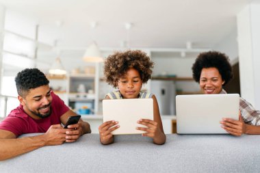 Teknolojik cihazlara takıntılı mutlu Afro-Amerikan ailesi dijital tablet, bilgisayar, akıllı telefonlar kullanıyor. İnternet sitesi, iş, eğitim ve internet üzerinden okuma, film veya bir mim için teknoloji