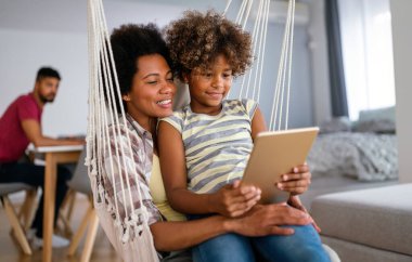 Çocuklu mutlu Afro-Amerikan anne portresi eğitim, eğlence ve oyun için dijital tablet kullanıyor. Teknoloji insanları kavramı