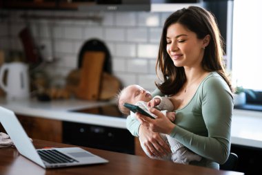Evde kal anne. Bebeğine bakarken uzaktan bilgisayarla çalış. Doğum izninde olan genç iş anneleri çocuk sahibi olarak masa başında serbest çalışmaya çalışıyor. Bilgisayarda genel çalışma