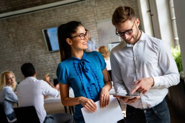Çok ırklı, mutlu iş adamları iş yeri tasarımcılığında birlikte eğleniyor, takım çalışması yapıyor ve sohbet ediyorlar..