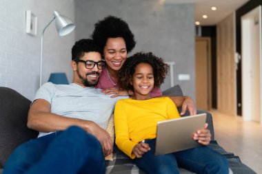 Mutlu siyah aile evde dijital cihazla eğleniyor. İnsanlar teknoloji aleti mutluluk kavramı.