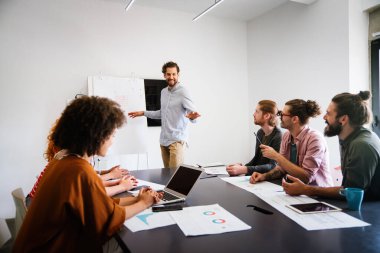 Mutlu iş arkadaşları, modern ofisteki iş arkadaşlarıyla iş başında ve toplantıdalar. Proje fikirlerini tartışmak veya strateji geliştirmek.