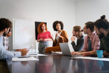 Mutlu, genç, Afro-Amerikan bayan liderleri, dost canlısı çeşitli meslektaşlarıyla toplantı yapıyor. Modern ofis odasında toplanıp proje fikirlerini tartışıyor ya da strateji geliştiriyor..