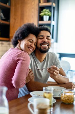 Mutlu çift mutfakta birlikte kahvaltı ediyor.
