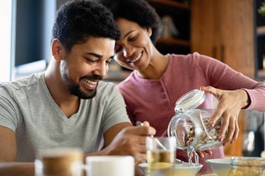 Mutfakta birlikte kahvaltı eden mutlu siyah çift.