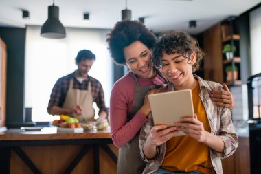 Mutlu çoklu etnik aileleri ve çocukları internette yemek pişirirken eğleniyorlar..