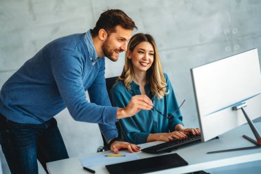 Tam konsantrasyon. Takım olarak çalışan ve kurumsal ofiste iletişim kuran bir grup genç iş adamı.