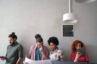 Çeşitli mutlu çalışanlar dijital cihazla raporları analiz ediyor, pazarlama, istatistiksel verileri tartışıyor, konuşuyor, beyin fırtınası yapıyor. İş toplantısı konsepti